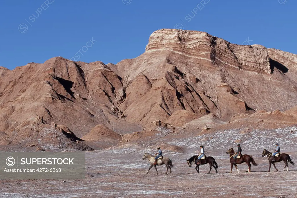 Tourists horse riding amongst the wind-eroded peaks and lunar landscape of Moon Valley