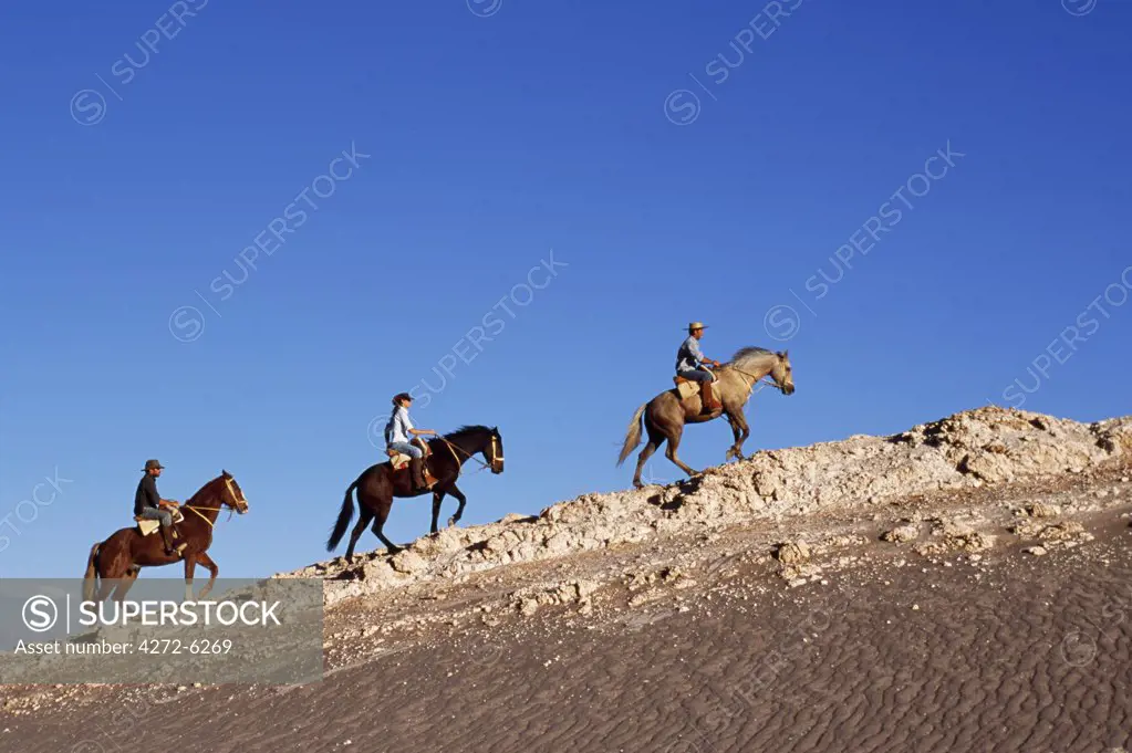 Horse riding along a ridge amongst the wind-eroded peaks and lunar landscape of  Moon Valley