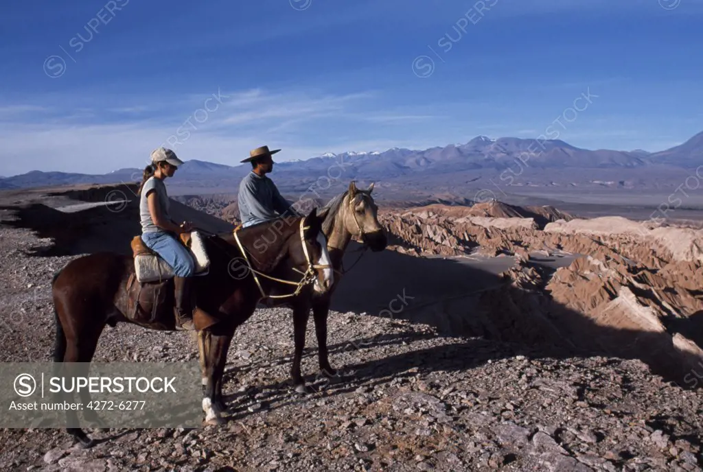 Looking out over the wind-eroded peaks and lunar landscape of  the Salt Mountains with the Andes in the background during a horse trek along Las Cornicas ridge