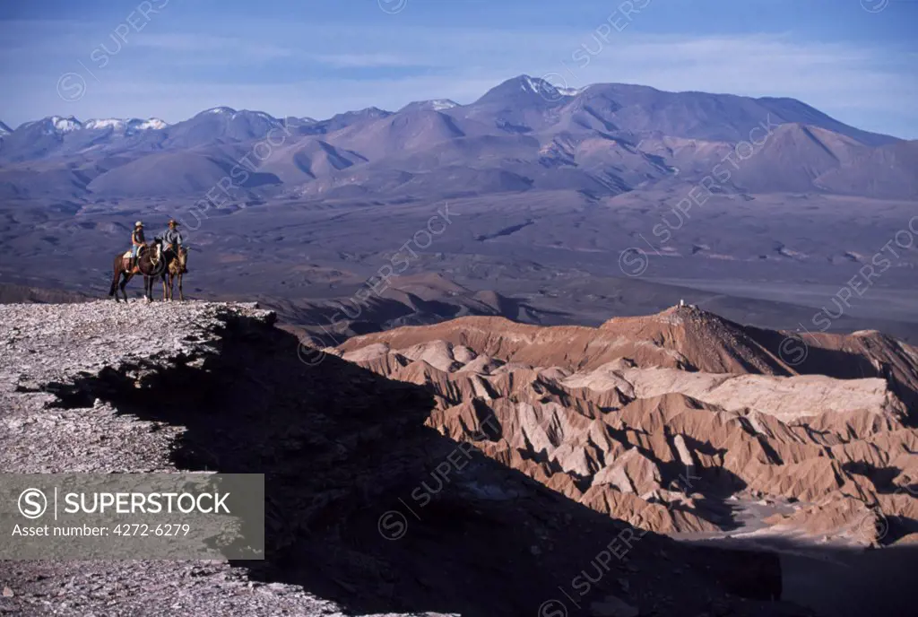 Looking out over the wind-eroded peaks and lunar landscape of  the Salt Mountains with the Andes in the background during a horse trek along Las Cornicas ridge
