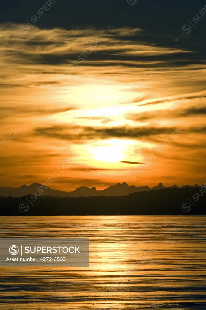 Chile, Patagonia.  Sunrise over the coastline and the entrance the seaway leading to Puerto Montt in southern Chile with the Andes Mountain Range in the background