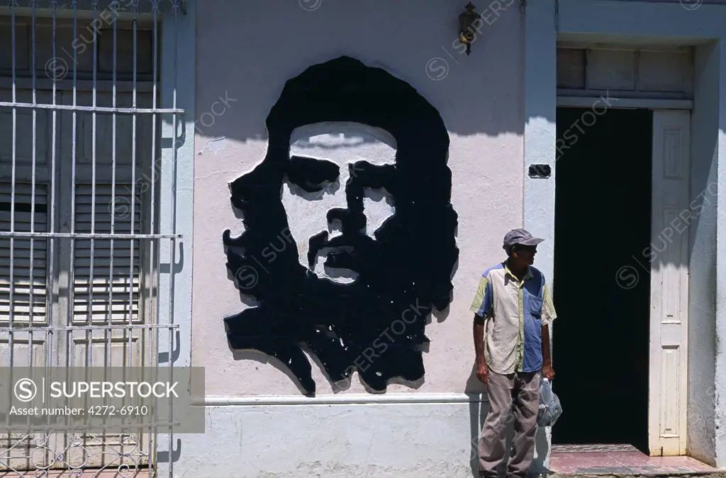 Old man standing next to wall mural of Che Guevara in the World Heritage town of Trinidad, Eastern Cuba