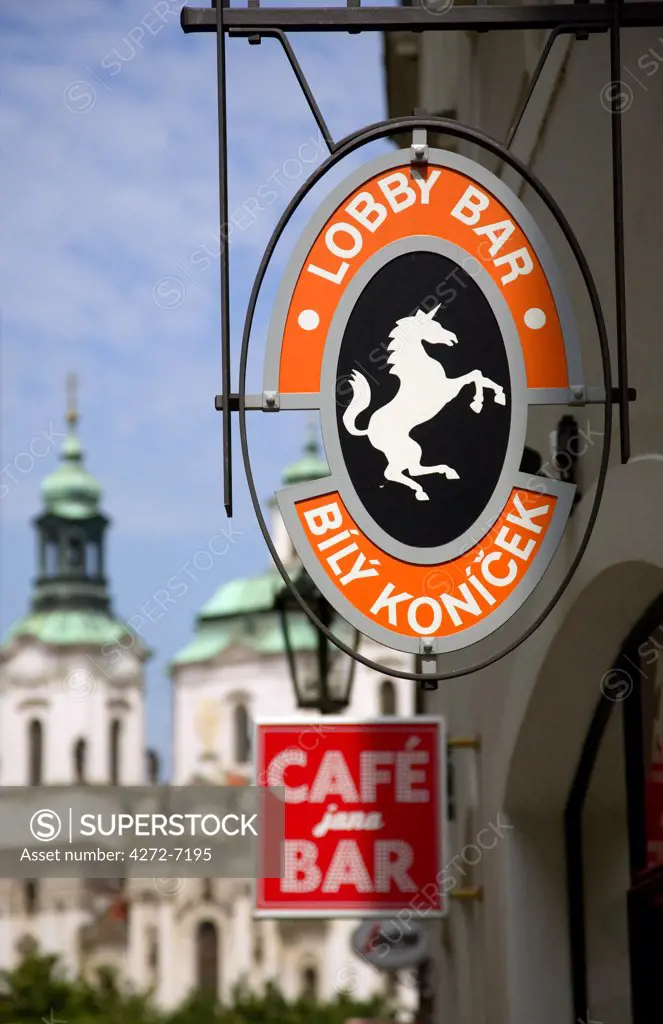 Czech Republic, Prague; Signs advertising bars with St.Nicholas Church in the background