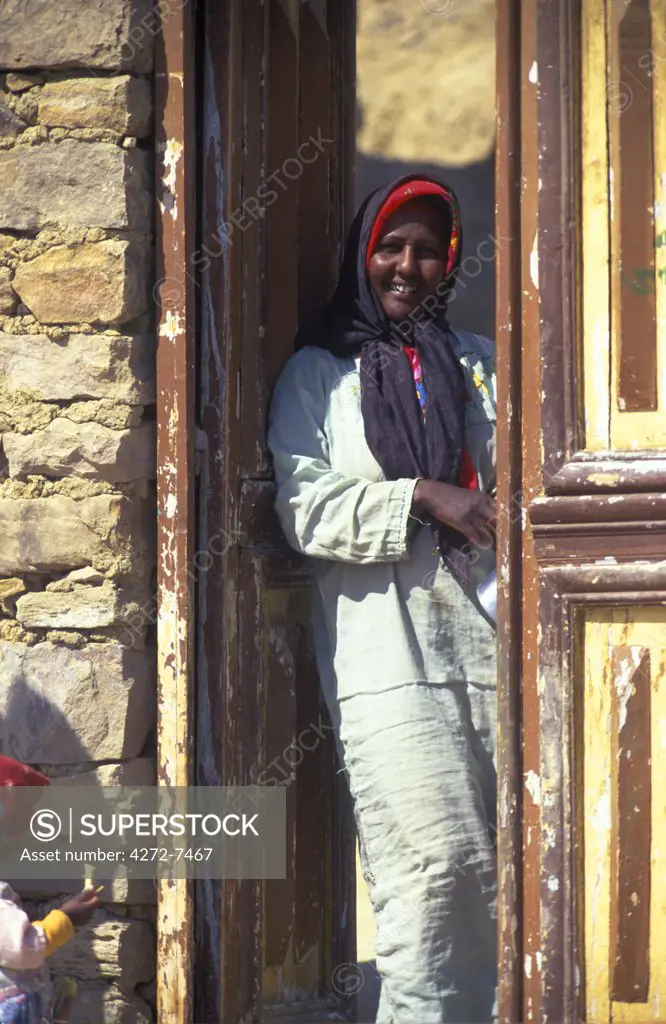 An Egyptian woman stands in the doorway of her house in the Nile Valley