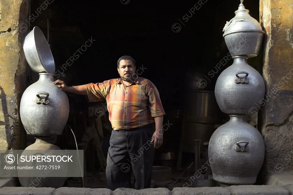 A metal smith stands in front of his workshop in the streets behind Khan el Khalili in Islamic Cairo.
