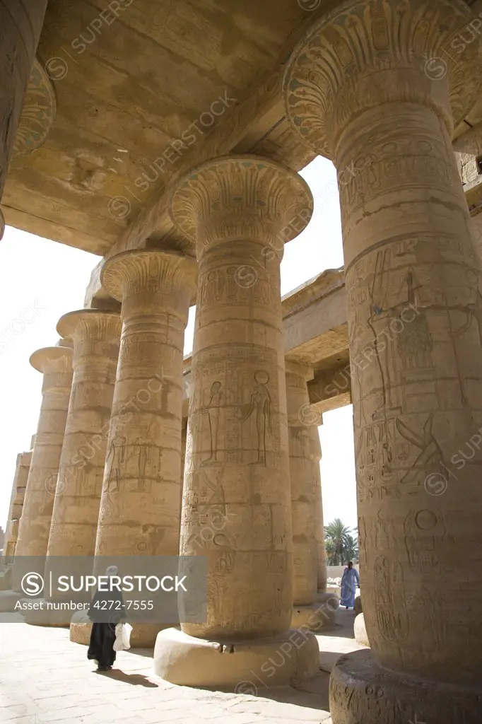 A man walks underneath the giant columns of the Hypostyle Hall in the Ramesseum, Luxor.