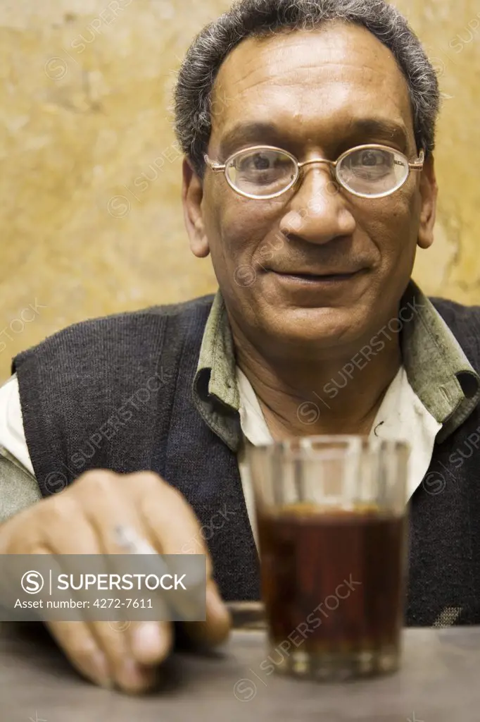 A jeweller in Khan el-Khalili enjoys a cup of tea and a cigarette, Cairo, Egypt.