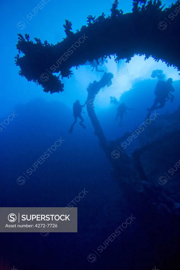 Egypt, Southern Region, Marsa Alam. Scuba divers at around 40m depth, exploring the wreck of the Aida at Brothers Islands, Red Sea.