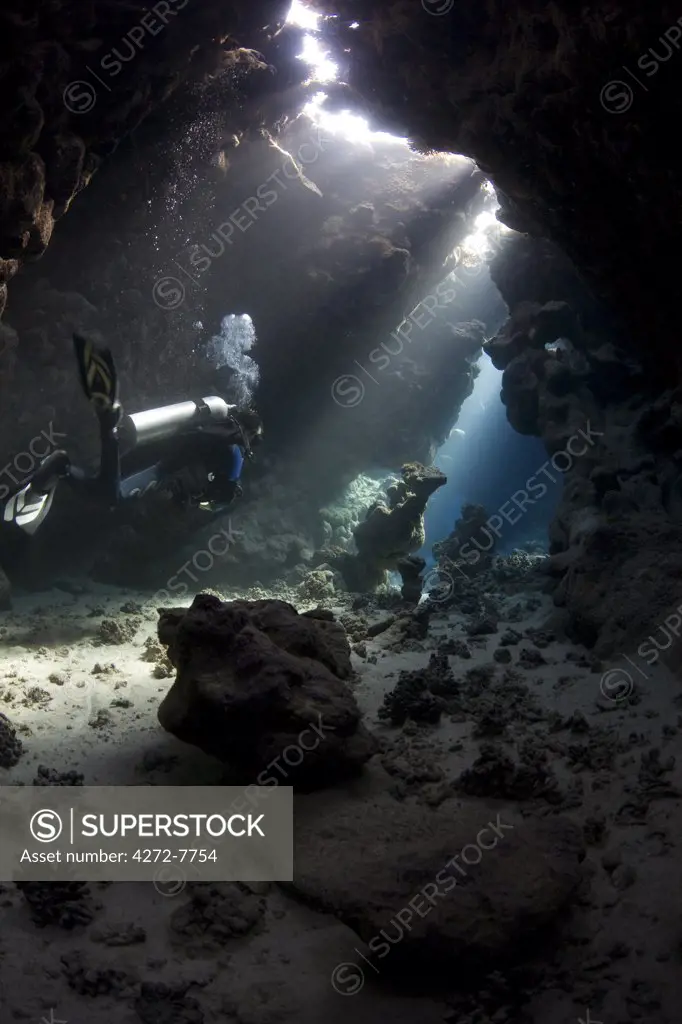 Egypt, Red Sea. A Diver explores the caves at St. John's Reef in the Egyptian Red Sea