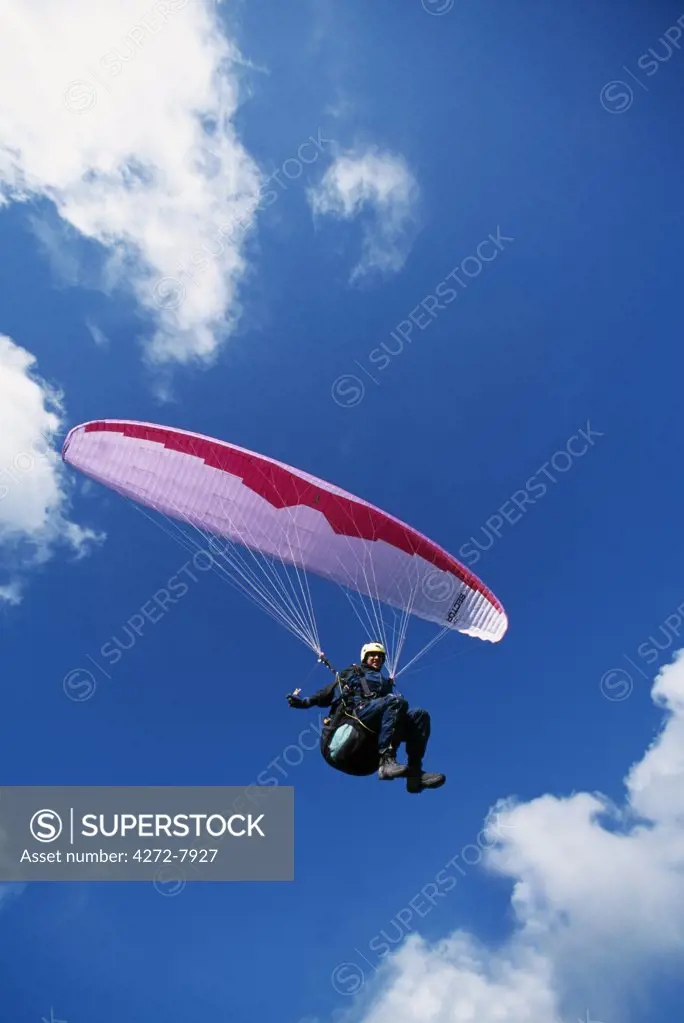 A paraglider soars on the South Downs in Sussex. The South Downs have become very popular for paragliding excellent conditions with the summer breezes.