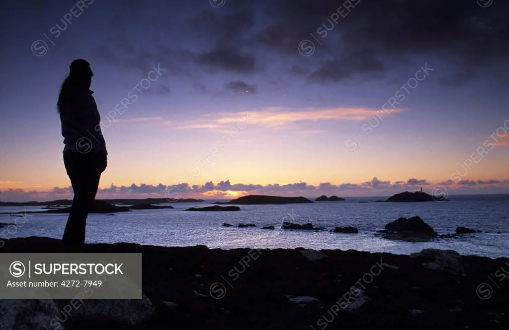 A tourist watched the sunset from Top Rock Cairn, St. Martin's.