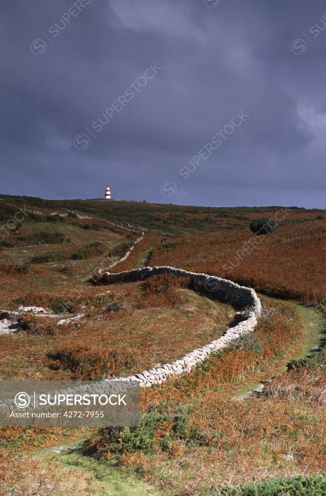 A traditional dry-stone wall leads the eye towards the daymark on Chapel Down, St. Martin's.