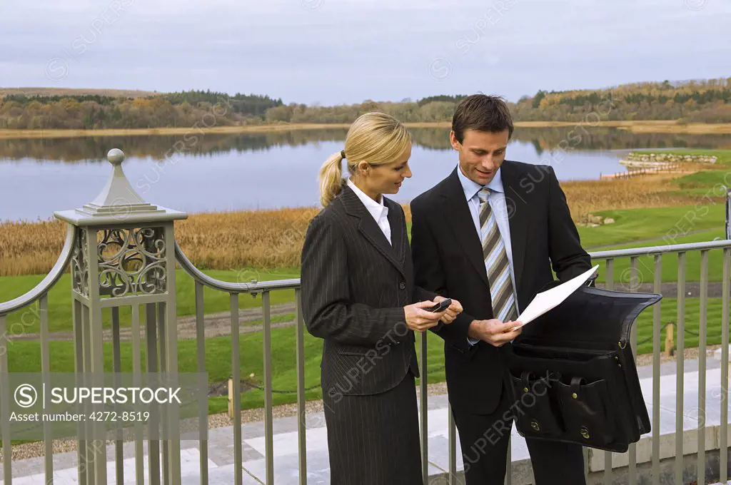 UK, Northern Ireland, Fermanagh, Enniskillen. Two business people have an informal meeting on the verandah of the Fermanagh Suite at the Lough Erne Golf Resort (MR)