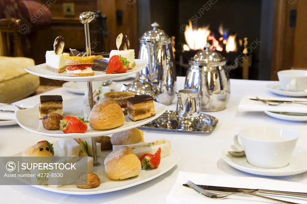 UK, Northern Ireland, Fermanagh, Enniskillen. Afternoon tea by the fire in the Garden Room at Lough Erne Golf Resort.