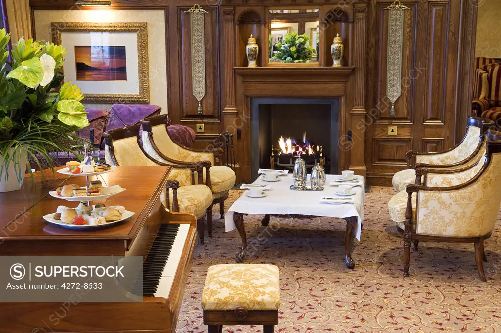 UK, Northern Ireland, Fermanagh, Enniskillen. Afternoon tea by the fire in the Garden Room at Lough Erne Golf Resort.