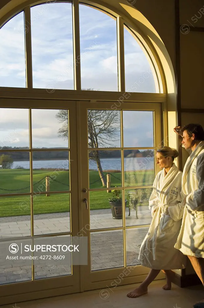 Northern Ireland, Fermanagh, Enniskillen. A couple look out of the window of the spa's rehydration room at the lake (MR).