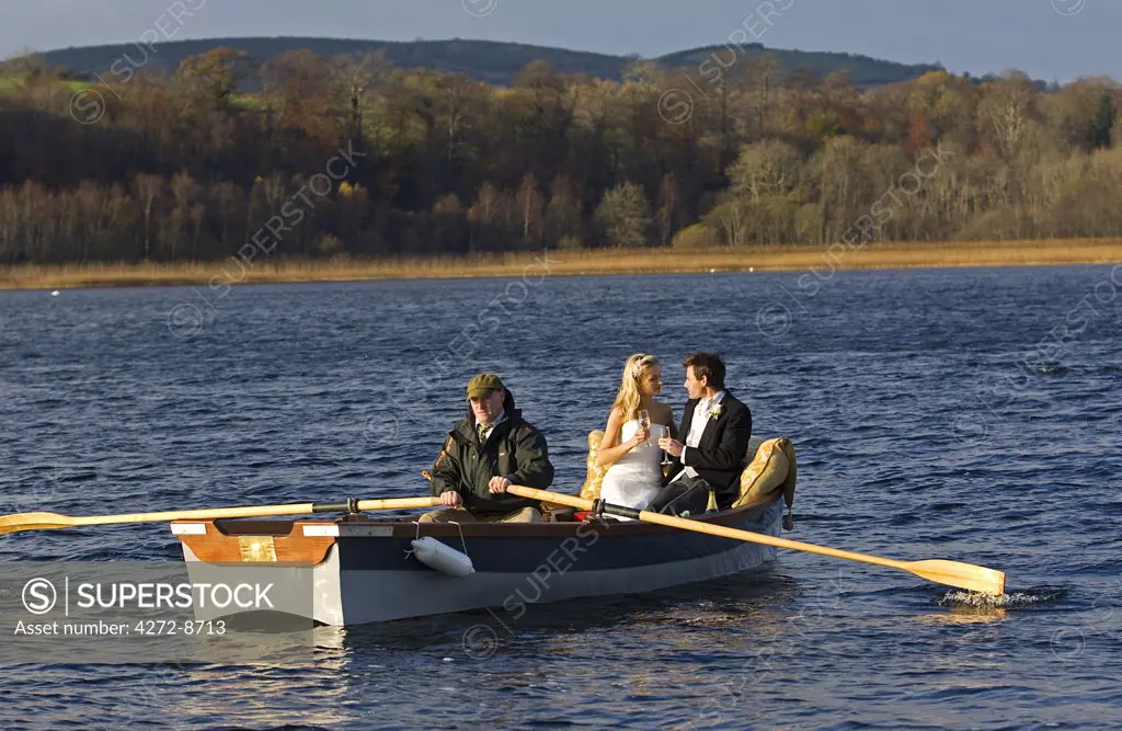 United Kingdom, Northern Ireland, Fermanagh, Enniskillen. Bride and groom are rowed across the lake during their wedding at the Lough Erne Golf Resort Hotel (MR).