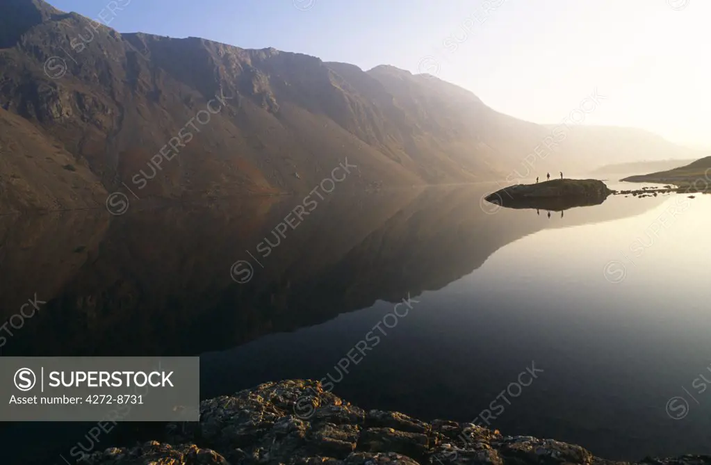 England, Cumbria, Lake District. Walkers beside the lake of Wastwater on the west side of Cumbria.