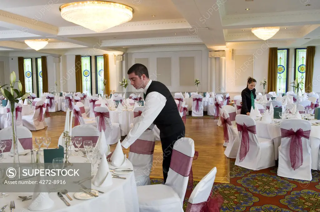 England, Northern Ireland, Londonderry. Staff setting up the dining room ready for a wedding at the Everglades Hotel. (MR).
