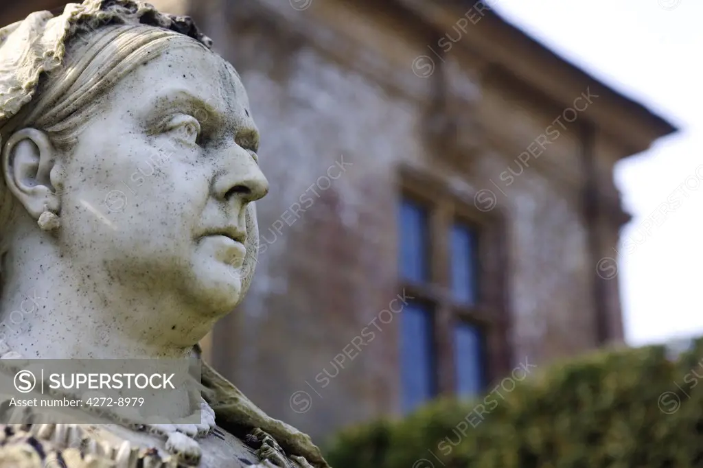England, Dorset. Athelhampton House - stern faced Queen Victoria overlooks Athelhampton House. It is one of the finest examples of 15th century domestic architecture in the country. Medieval in style predominantly and surrounded by walls, water features and secluded courts.