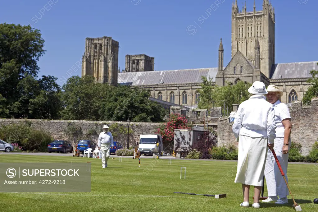 England, Somerset, Wells.   With Wells Cathedral in the background a game of summer croquet takes place on the lawns in front of the Bishops Palace
