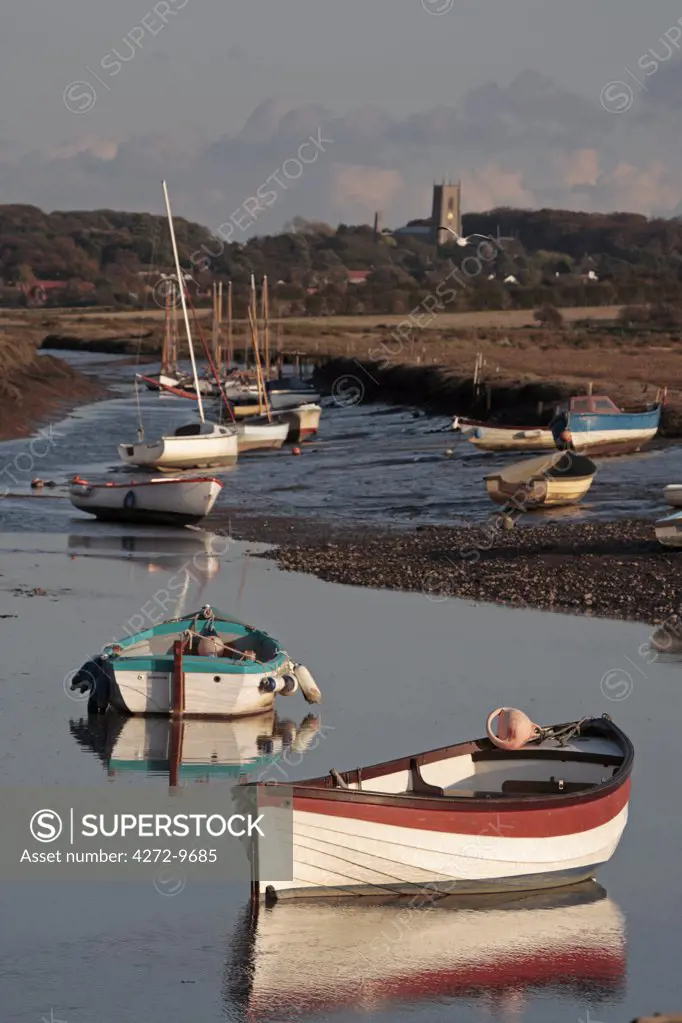 England, Norfolk, Morston Quay. Rowing boats and sailing dinghies at low tide.