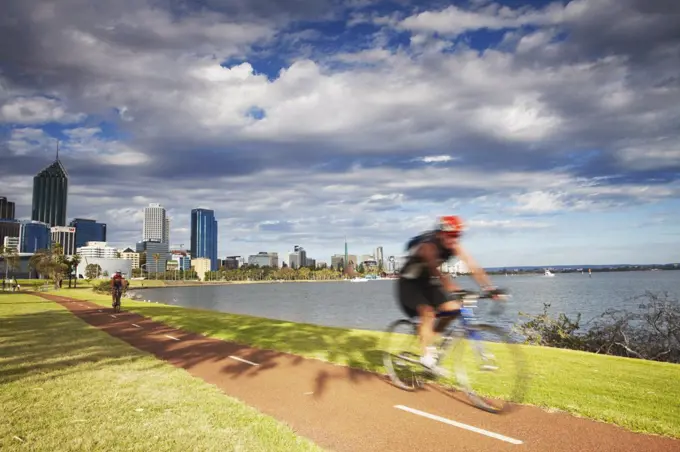 People cycling alongside Swan River, Perth, Western Australia, Australia