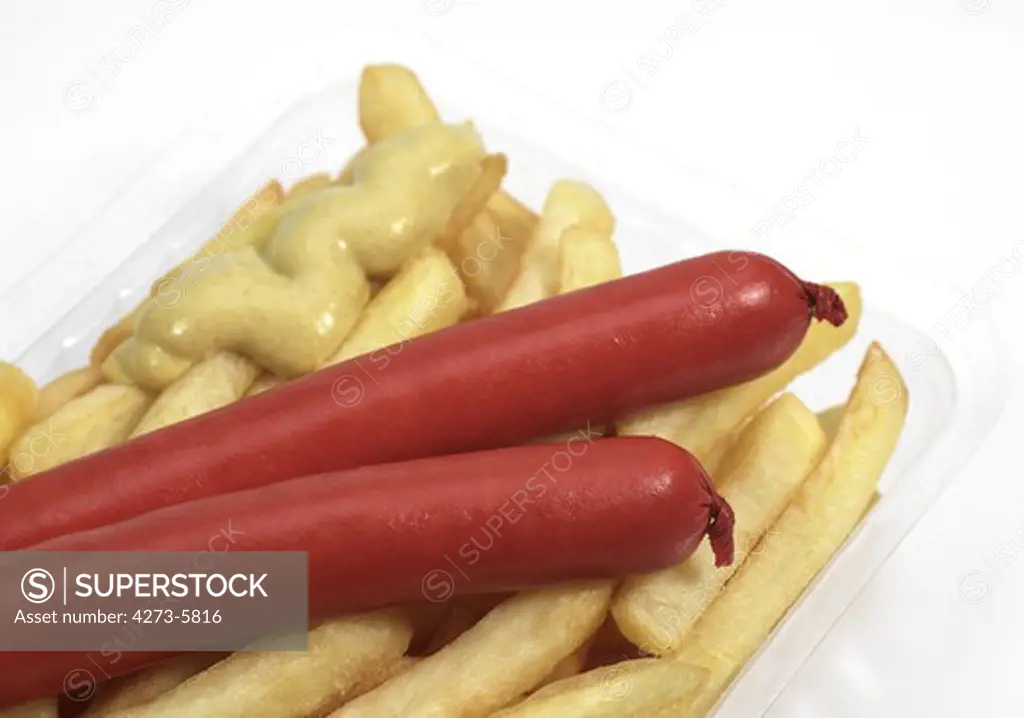 Sausage, Mustard And French Fries Against White Background