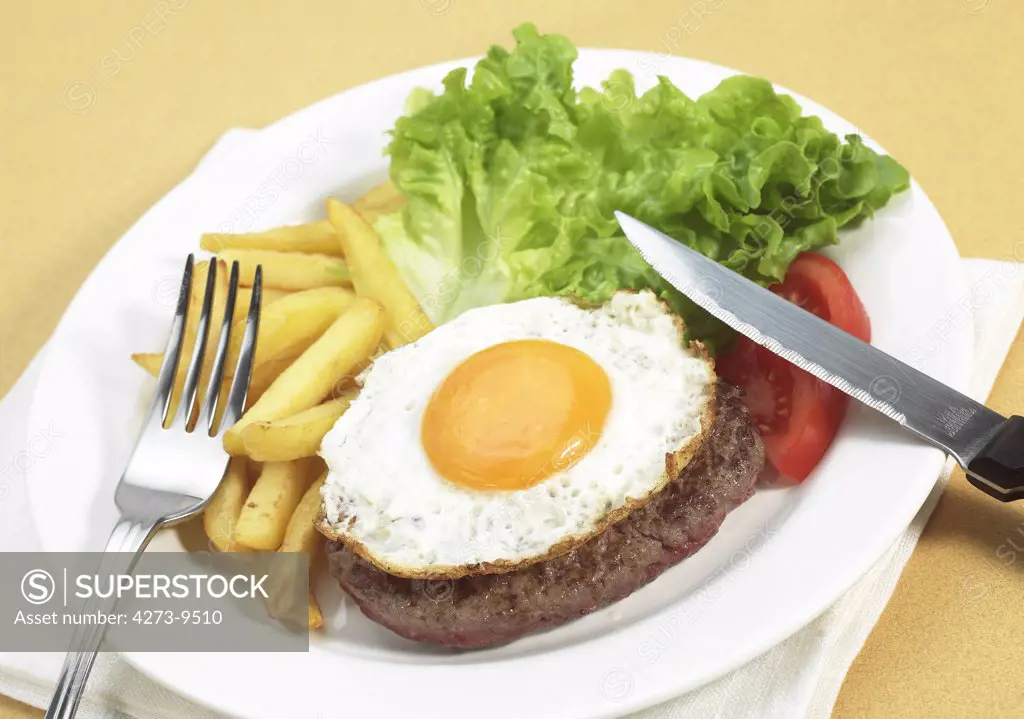 Steak With Egg, French Fries And Salad On Plate