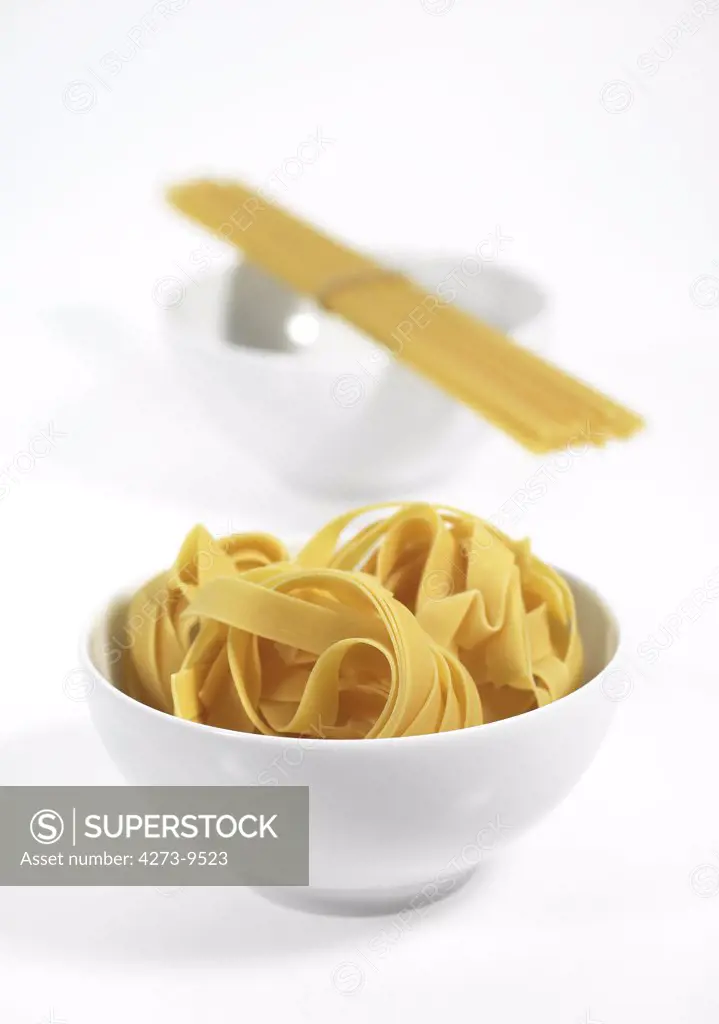 Spaghetti And Tagliatelle Pasta Against White Background