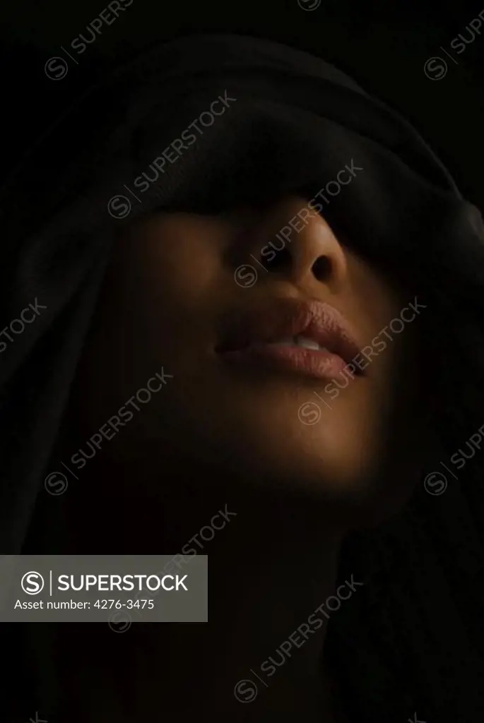 Woman with eyes concealed beneath hood