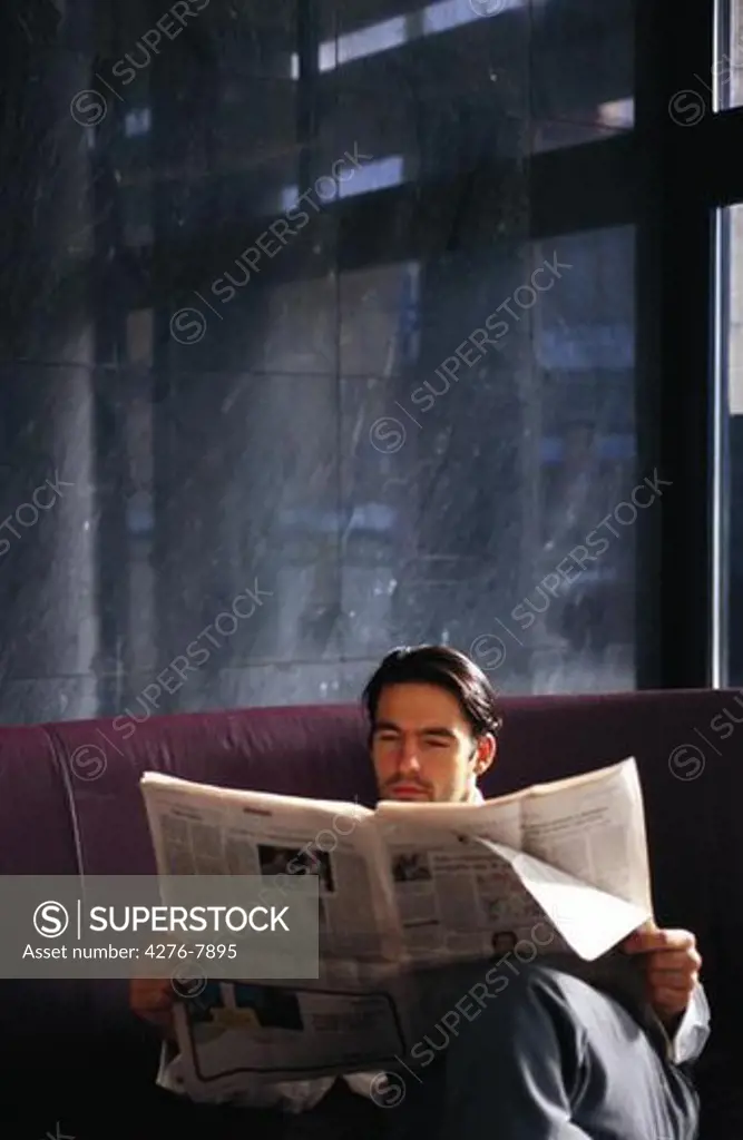 Businessman sitting and reading newspaper
