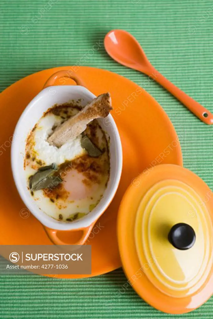 Oeufs en cocotte with herbs and spices, served with sliced bread strip