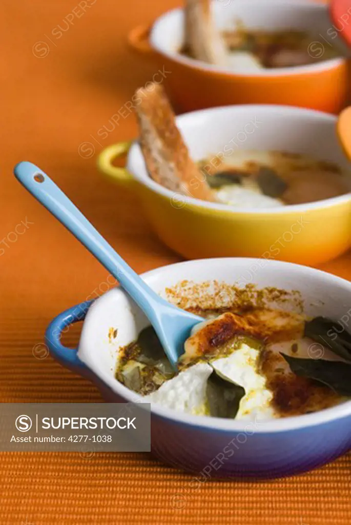 Oeufs en cocotte with herbs and spices, served in individual ramekins