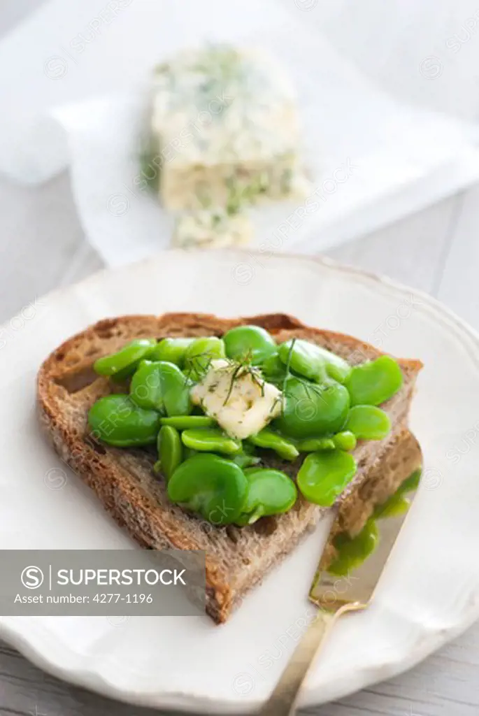 Sliced bread topped with peas and pastis butter