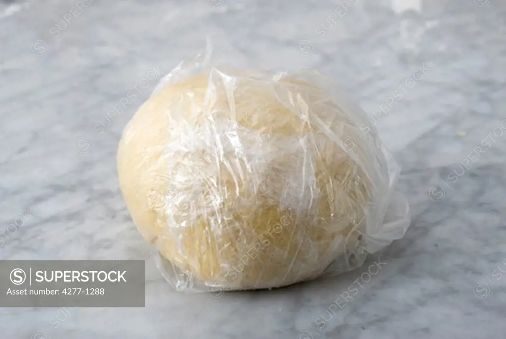 Fresh ball of dough wrapped in cellophane