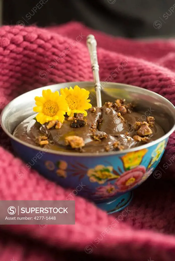 Chocolate mousse topped with caramelized hazelnuts, garnished with flowers