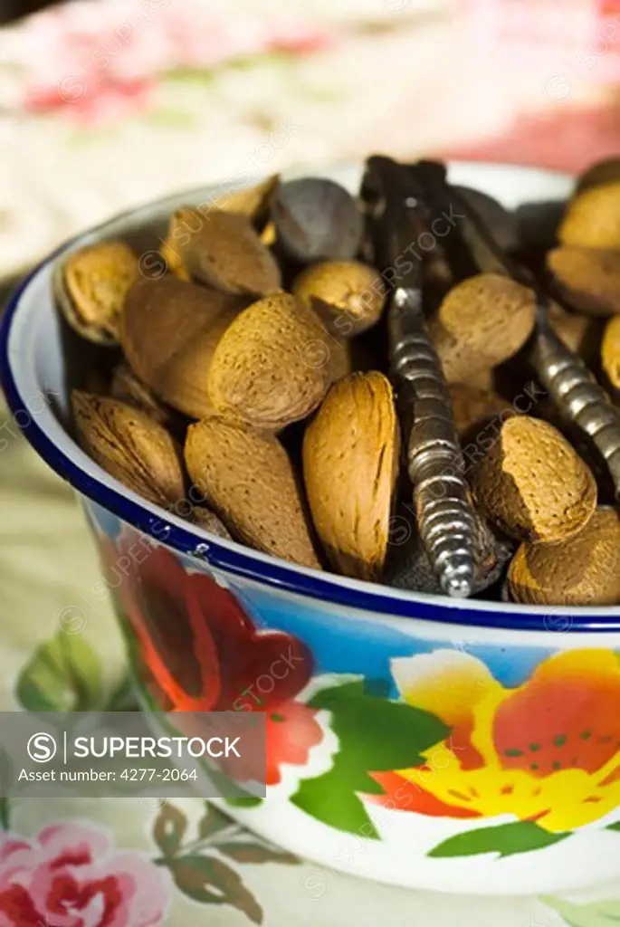 Almonds and nutcracker in bowl