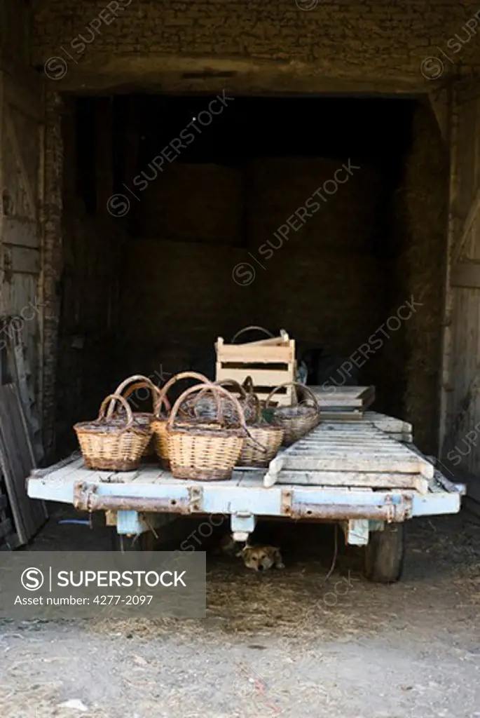 Baskets and ladders on trailer parked outside barn