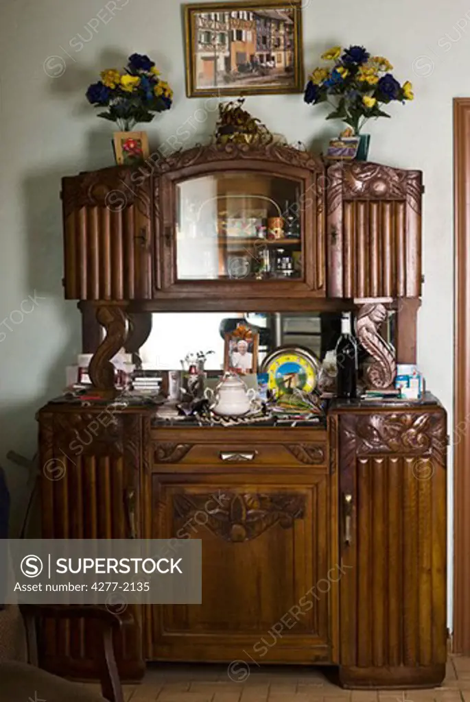 Cabinet cluttered with knickknacks and other household objects