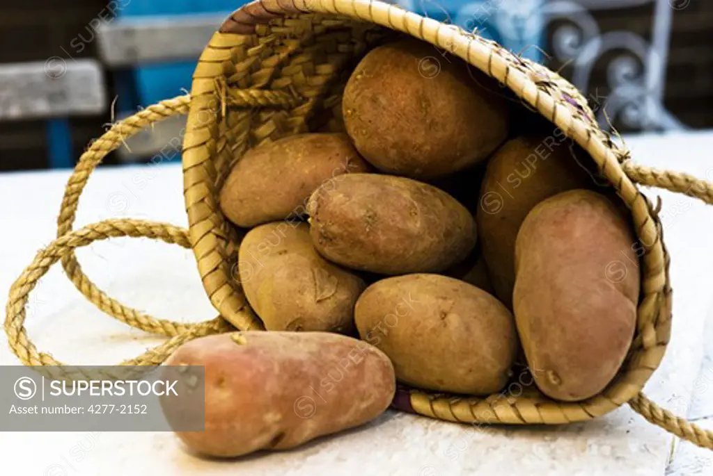 Raw potatoes spilling out of basket