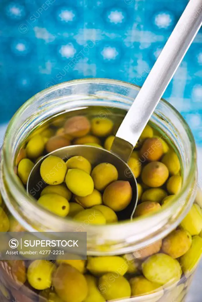 Green olives in jar with scoop