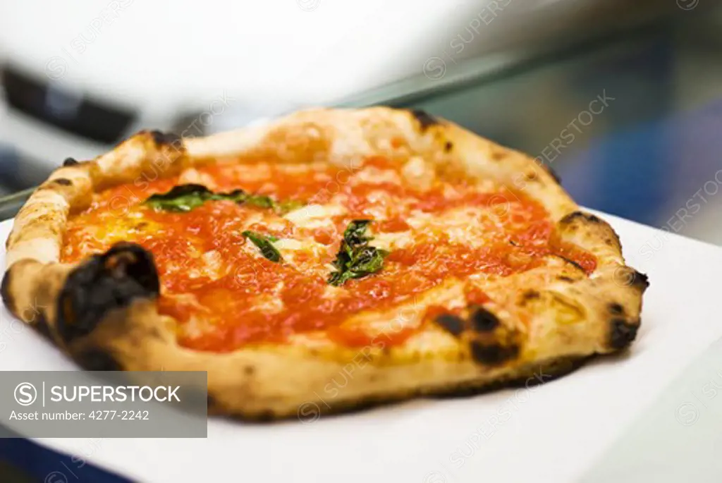 Fresh pizza with tomato sauce and basil