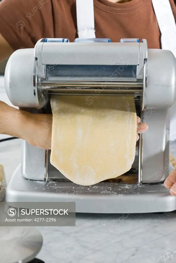 Making lasagna noodles, feeding pasta dough through pasta machine