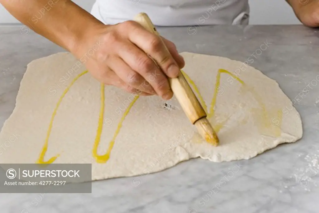 Brushing dough with olive oil