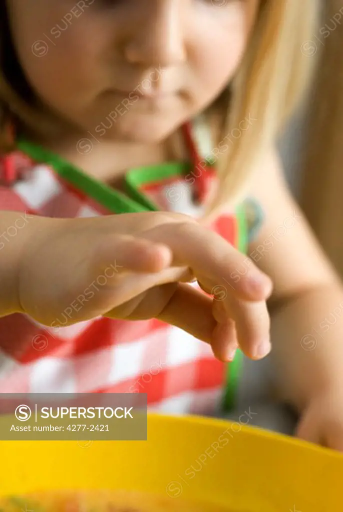 Little girl preparing food, cropped