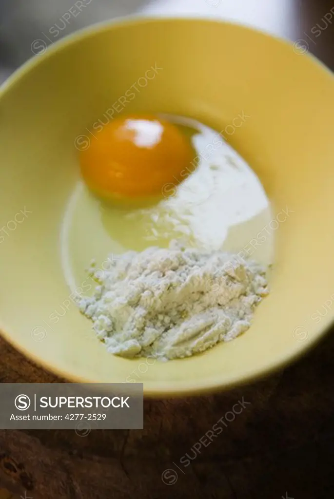 Flour and egg yolk in bowl