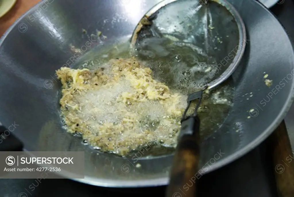 Preparing fish fritters, frying fish in coconut oil