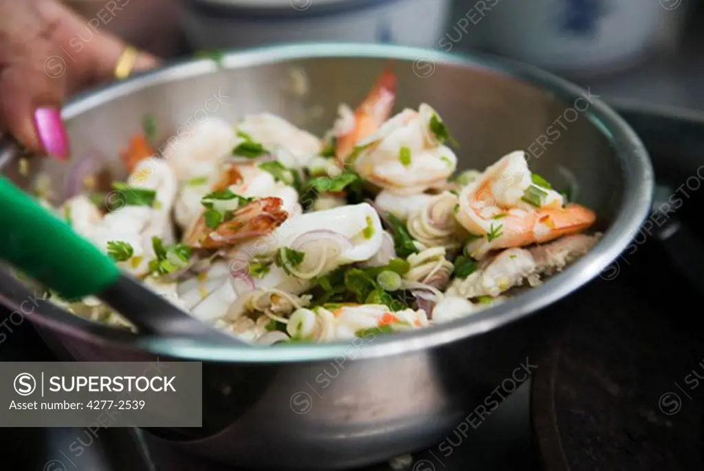 Preparing seafood salad with mint