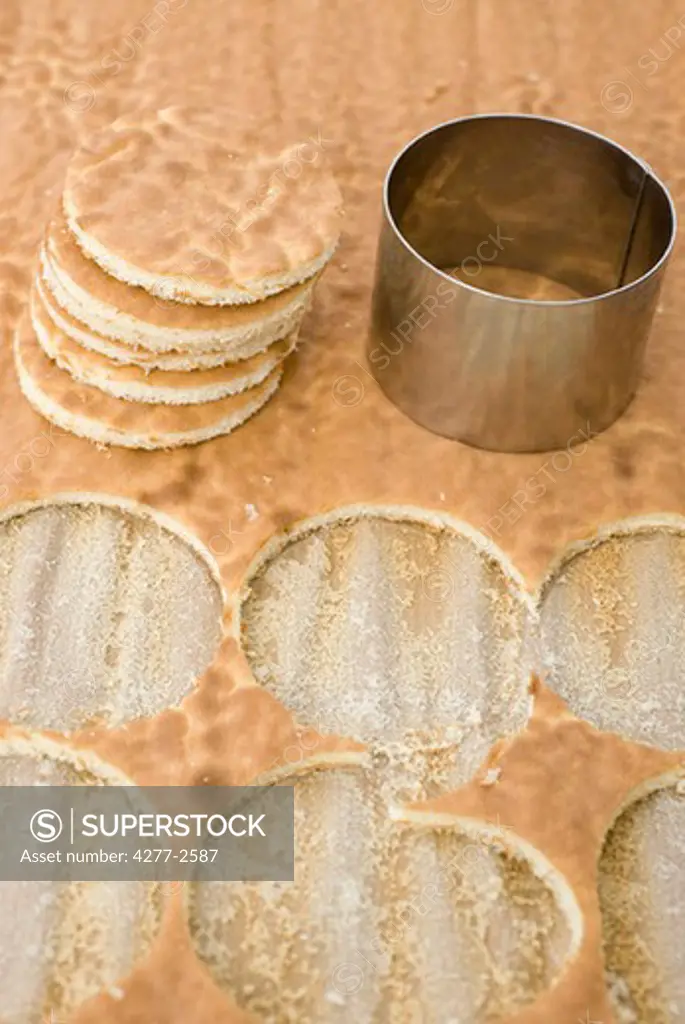 Cutting circular shaped cookies out of genoise cake